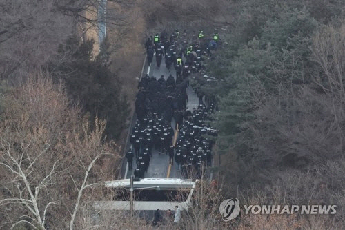 고위공직자범죄수사처(공수처)와 경찰이 윤석열 대통령에 대한 2차 체포영장 집행에 나선 15일 용산구 한남동 대통령 관저에서 경찰 병력이 2차 저지선을 넘어 진입하고 있다.   [연합뉴스]